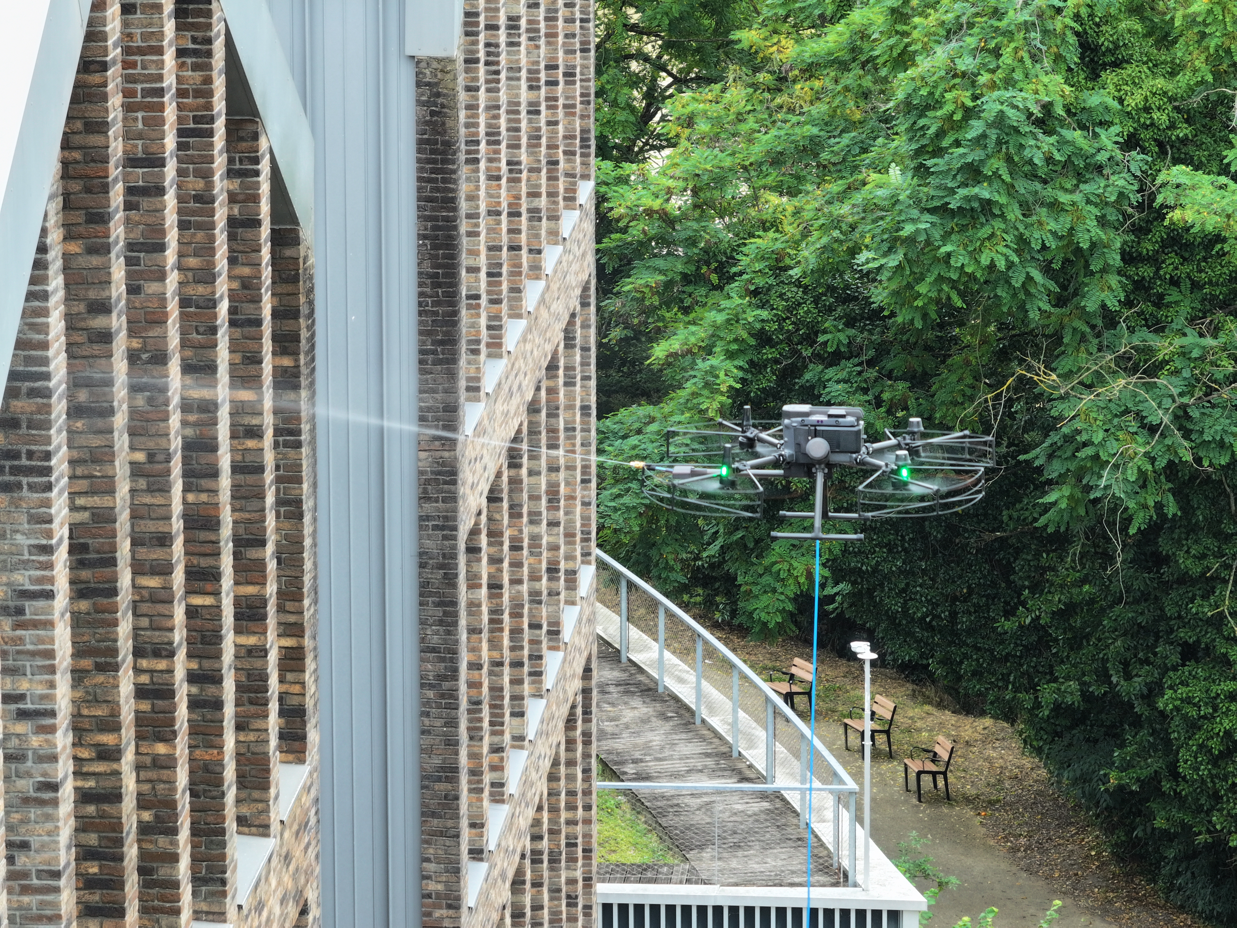 Nettoyage de façade par drone — pulvérisation sur bâtiment en brique, OrizonDrone